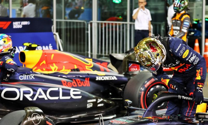 Win Red Bull model stand next to Verstappen and Perez